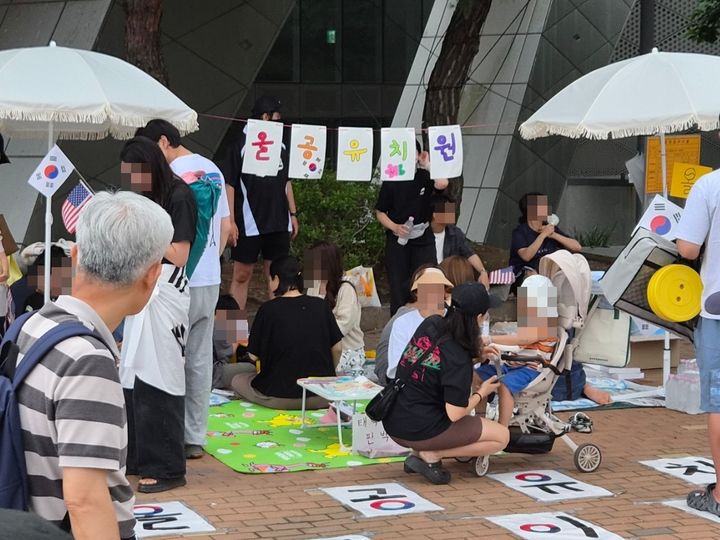 [서울=뉴시스] 이태성 기자 = 21일 오후 서울 송파구 올림픽공원 개표소 봉쇄 시위 장소 인근에 태극기 그리기, 판박이 스티커 등 체험이 가능한 '올공 유치원'이 조성돼 있다. 2026.06.21. victory@newsis.com *재판매 및 DB 금지
