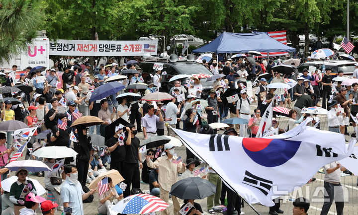 [서울=뉴시스] 김금보 기자 = 21일 서울 송파구 올림픽공원 핸드볼경기장 앞에서 시민들이 참정권 침해 사태와 관련해 '부정선거·재선거·당일투표·수개표' 구호를 외치고 있다. 2026.06.21. kgb@newsis.com