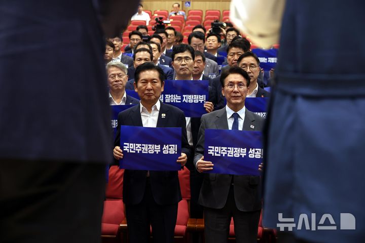 [서울=뉴시스] 조성봉 기자 = 김민석 국무총리와 정청래 더불어민주당 대표를 비롯한 참석자들이 21일 오후 서울 여의도 국회 의원회관 대회의실에서 열린 2026 6.3지방선거 단체장 당선자 워크숍에서 손피켓을 들고 결의문 낭독을 지켜보고 있다. 2026.06.21. suncho21@newsis.com