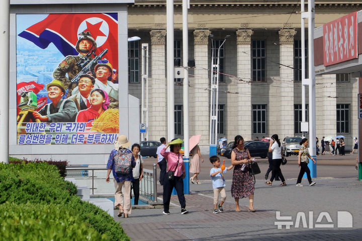 [평양=AP/뉴시스] 22일 북한 평양 중구역에서 주민들이 국가 번영을 위한 홍보물이 걸려 있는 거리를 지나고 있다. 2026.06.22. 