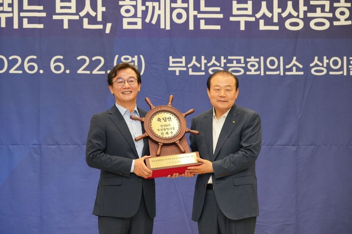[부산=뉴시스] 양재생 부산상공회의소 회장(오른쪽)이 전재수 부산시장 당선인에게 축하패를 전달하고 있다. (사진=부산상의 제공) 2026.06.22. photo@newsis.com *재판매 및 DB 금지