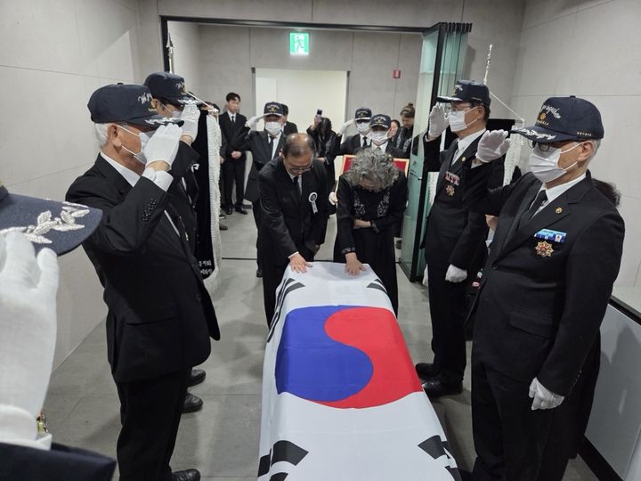 [화성=뉴시스] 대한민국무공수훈자회 화성시지회 선양단이 국가유공자의 관에 태극기를 덮는 태극기 관포 의식을 진행하고 있다. (사진=화성시 제공) 2026.06.22. photo@newsis.com *재판매 및 DB 금지
