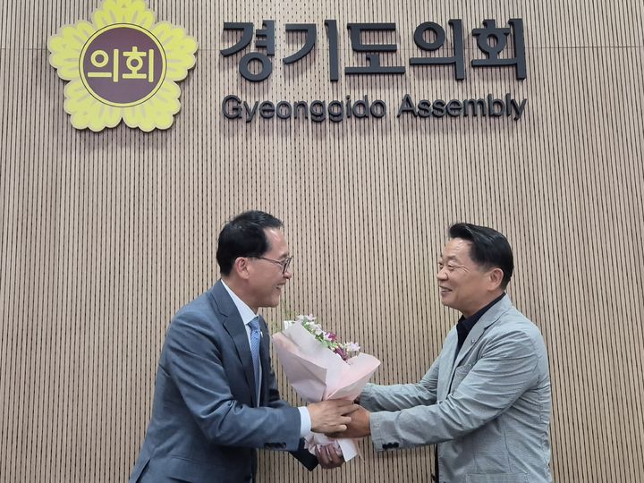 [수원=뉴시스] 이병희 기자 = 제12대 경기도의회 국민의힘 대표의원으로 선출된 방성환 의원이 22일 안광률 민주당 대표의원에게 당선 축하 꽃다발을 건네고 있다. 2026.06.22. iambh@newsis.com *재판매 및 DB 금지