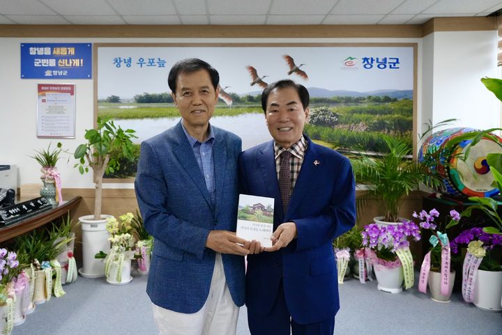 [창녕=뉴시스] 허병찬 시인이 성낙인 경남 창녕군수에게 시집을 전달하고 있다. (사진=창녕군 제공) 2026.06.23. photo@newsis.com *재판매 및 DB 금지