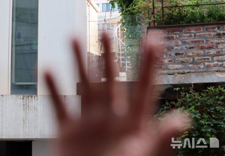 [서울=뉴시스] 이영환 기자 = 23일 오전 한성숙 국무총리 후보자가 보유한 서울 종로구 연건동 건물에서 불법 증축시설 철거 작업이 진행되는 가운데 관계자가 취재를 제지 하고 있다.한 후보자가 매입한 종로구 연건동 소재 단독주택 2채로 한 후보자의 동생이 임대받아 카페로 운영 중이다.두 건물을 잇는 통로가 건축물대장 및 현황도에 등재되지 않은 무단증축 구조물로서 인사청문회를 이틀 앞둔 이날부터 철거작업에 들어갔다. 2026.06.23. 20hwan@newsis.com