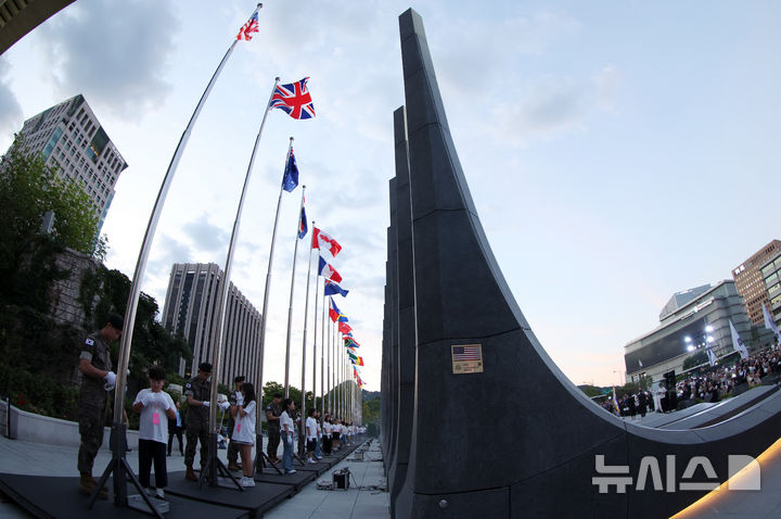 [서울=뉴시스] 조성우 기자 = 23일 서울 종로구 광화문광장 감사의 정원에서 열린 6·25전쟁 제76주년 기념식에서 어린이기자단과 수방사 군인들이 참전국 국기 게양식을 하고 있다.&nbsp; 2026.06.23. xconfind@newsis.com