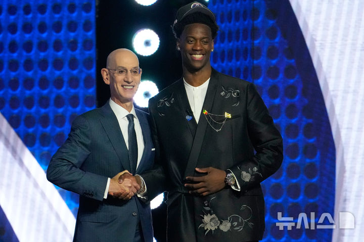 [뉴욕=AP/뉴시스] 2026 미국프로농구(NBA) 드래프트에서 전체 1순위로 워싱턴 위저즈 지명을 받은 AJ 디반사와 애덤 실버 NBA 커미셔너. 2026.06.24