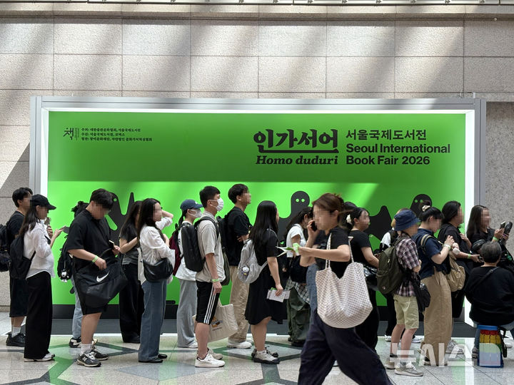 [서울=뉴시스] 한이재 기자 = 24일 사람들이 서울 강남구 코엑스에서 2026 서울국제도서전 입장을 기다리고 있다. 뒤로는 올해 도서전 주제인 인간선언이 적혀 있다. 2026.06.24. nowone@newsis.com