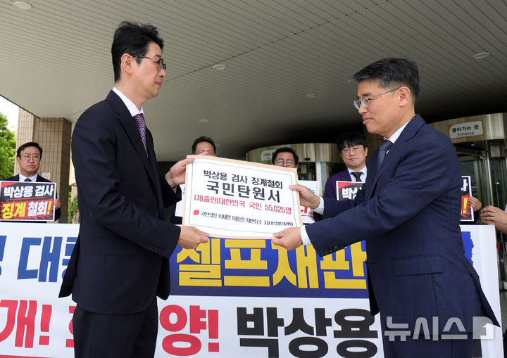 [서울=뉴시스] 홍효식 기자 = 국민의힘 '이재명 대통령 재판취소 저지 특별위원회' 주진우(왼쪽) 위원장이 24일 오전 경기도 과천시 정부과천청사 민원실 앞에서 박상용 검사 징계 철회를 촉구하는 국민탄원서 전달 기자회견을 마친 뒤 법무부 김상권 정책기획관에 국민탄원서를 전달하고 있다. 2026.06.24. yesphoto@newsis.com