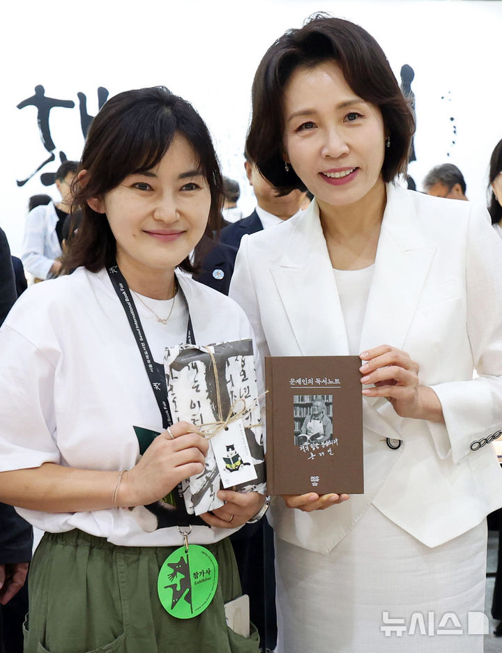[서울=뉴시스] 최동준 기자 = 김혜경 여사가 24일 서울 강남구 코엑스에서 열린 2026 서울국제도서전 개막식에서 전시관을 관람하며 참가자와 기념촬영을 하고 있다. (청와대통신사진기자단) 2026.06.24. photocdj@newsis.com