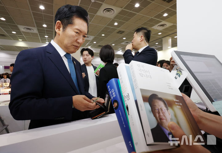 [서울=뉴시스] 조성우 기자 = 정청래 더불어민주당 전 대표가 24일 서울 강남구 코엑스에서 열린 2026 서울국제도서전 평산책방 부스에서 문재인 전 대통령을 만난 뒤 대통령 관련 도서를 구매하고 있다. 2026.06.24. xconfind@newsis.com