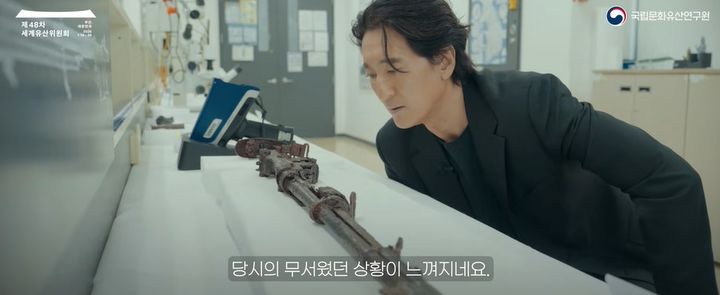 [서울=뉴시스] 2025년 6.25전쟁 전사자 유품 중 보존처리 완료된 M1 소총을 관찰하는 배우 신현준 (사진=국가유산청 제공) 2026.06.25. photo@newsis.com *재판매 및 DB 금지