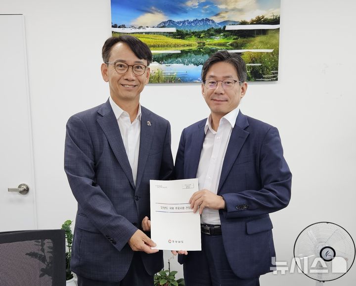 [세종=뉴시스] 경남도 김명주(왼쪽) 경제부지사가 25일 정부세종청사 기획예산처를 방문해 조용범 예산실장에게 내년도 주요사업 국비 지원 요청 내용이 담긴 소책자를 전달하고 있다. (사진=경남도 제공) 2026.06.25. photo@newsis.com
