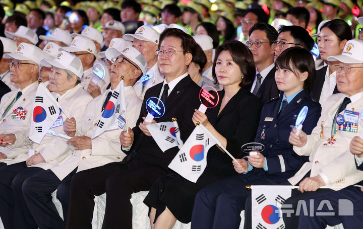 [수원=뉴시스] 고범준 기자 = 이재명 대통령과 김혜경 여사가 25일 경기 수원컨벤션센터에서 열린 6·25전쟁 제76주년 기념식에서 합창단의 기념 공연을 관람하며 참석자들과 응원봉을 흔들고 있다. 2026.06.25. bjko@newsis.com