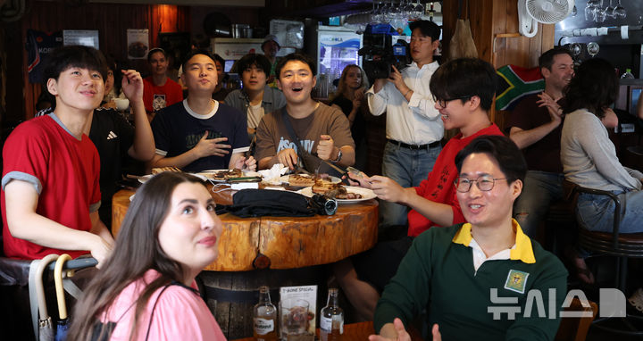 [서울=뉴시스] 김선웅 기자 = 25일 서울 용산구 이태원 소재 남아공 음식점 브라이리퍼블릭에서 내외국인들이 2026 중남미 월드컵 대한민국과 남아프리카 공화국의 경기 중계 방송을 시청하고 있다. 2026.06.25. mangusta@newsis.com