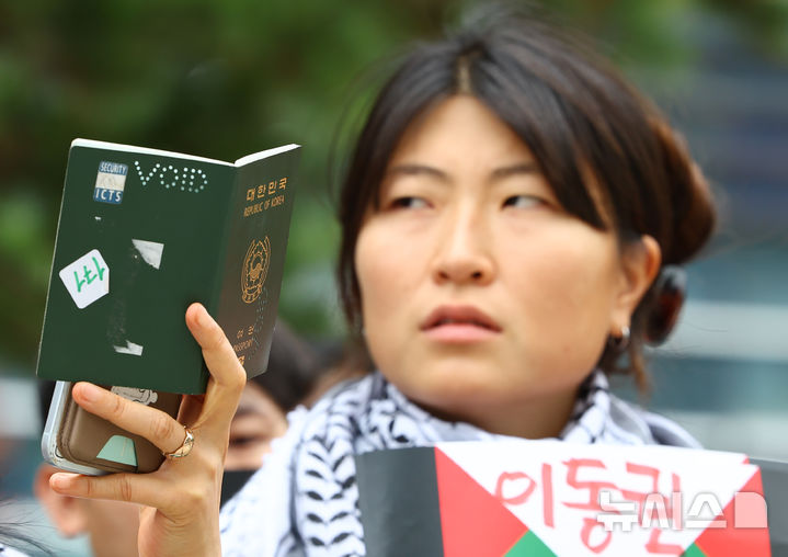 [서울=뉴시스] 황준선 기자 = 25일 서울 서초구 서울행정법원 앞에서 가자지구로 가던 구호선에 탑승했다가 이스라엘군에 나포된 후 풀려난 팔레스타인 해방을 위한 항해 한국본부 김아현(활동명 해초)씨의 여권 무효화 취소소송 첫 변론 기자회견에서 한 활동가가 김씨의 무효화 된 여권을 들어 보이고 있다. 2026.06.25. hwang@newsis.com