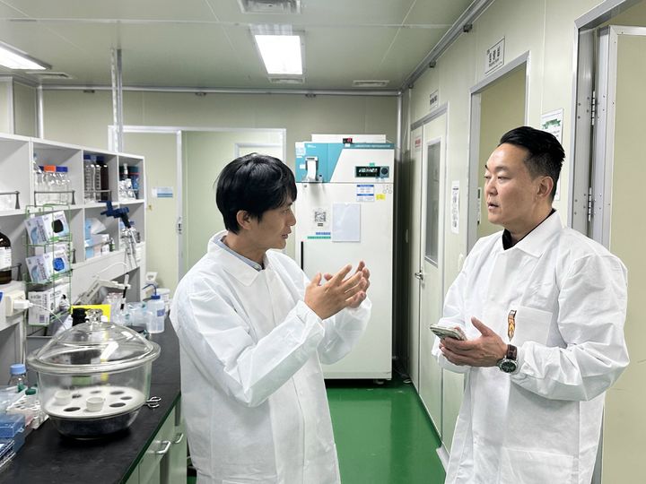 [서울=뉴시스] HLB펩 심경재 대표이사(왼쪽)가 GMP 생산시설을 방문한 노바브릿지 피터 리 대표이사에게 펩타이드 생산 공정에 대해 설명하고 있다. (사진=HLB펩 제공) 2026.6.26. photo@newsis.com *재판매 및 DB 금지