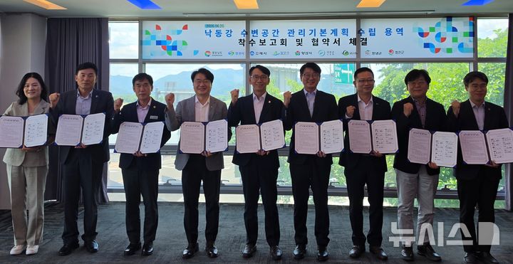 [함안=뉴시스]26일 경남 함안군 칠북면 창녕함안보 통합물관리센터에서 경남도 김명주(가운데) 경제부지사와 낙동강 연접 창원시 등 8개 시군 부단체장이 '낙동강 수변공간 관리 협의체 구성' 등 관련 업무협약을 체결한 후 기념촬영하고 있다.(사진=경남도 제공) 2026.06.26. photo@newsis.com