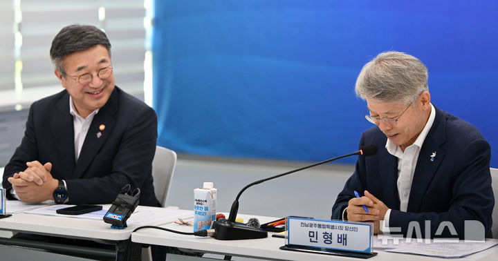 [나주=뉴시스] 이현행 기자 = 윤호중 행정안전부 장관이 26일 오후 전남 나주시 빛가람복합문화체육센터에 마련된 '전남광주대전환기획위원회'를 방문, 출범준비 현장 점검 회의 중 민형배 통합특별시 당선인을 바라보며 웃고 있다. 2026.06.26. lhh@newsis.com