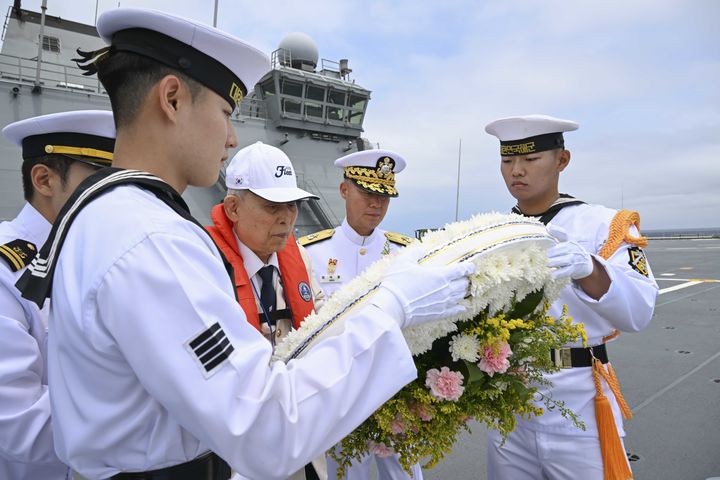 [부산=뉴시스] 제76주년 대한해협해전 전승기념행사가 열린 26일 부산 인근 대한해협해전 해역에 도착한 마라도함(1만4500t급)에서 참전용사 황상영(94)옹과 장석용 해군작전사령부 참모장이 해상헌화를 하고 있다. (사진=해군작전사 제공) 2026.06.26. photo@newsis.com *재판매 및 DB 금지