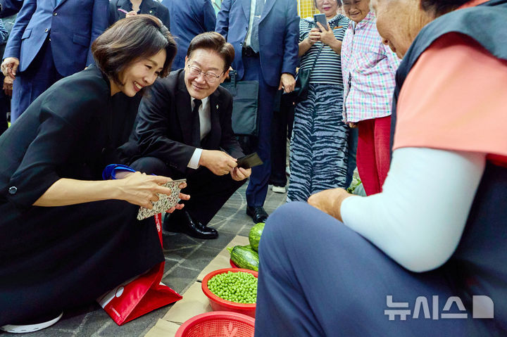 [서울=뉴시스] 최동준 기자 = 이재명 대통령과 김혜경 여사가 25일 경기 수원 팔달문시장을 방문해 먹거리를 구매하고 있다. (사진=청와대 제공) 2026.06.25. photo@newsis.com *재판매 및 DB 금지