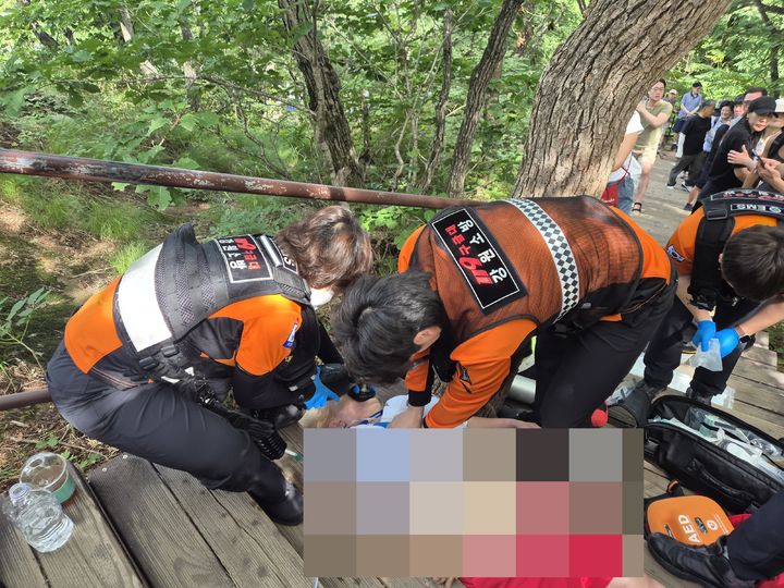 [속초=뉴시스] 27일 폴란드 국적 60대 여성이 설악산에서 심정지 증상을 보이며 갑자기 쓰러져 구급대원이 긴급 조치에 나서고 있다.(사진=설악산사무소 제공)photo@newsis.com *재판매 및 DB 금지