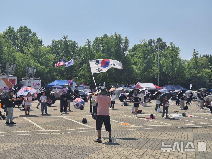 [서울=뉴시스] 조성하 기자 = 28일 오전 서울 송파구 올림픽공원 핸드볼경기장 1-3게이트 앞에서 개표소 봉쇄 시위 참가자들이 태극기와 성조기를 흔들며 집회를 이어가고 있다. 2026.06.28. create@newsis.com