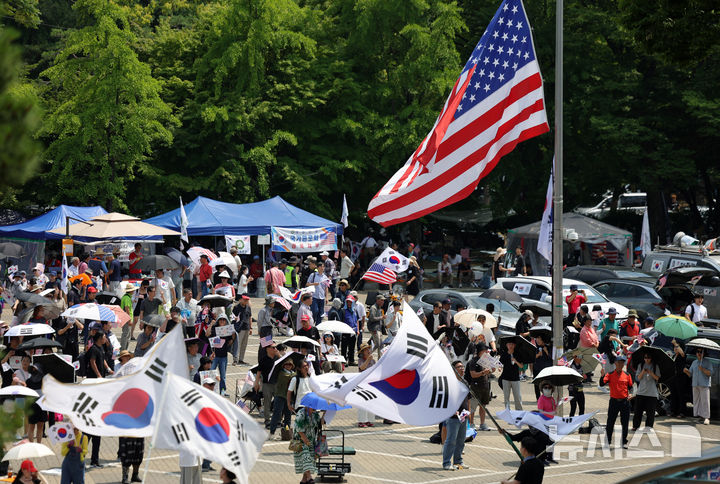 [서울=뉴시스] 홍효식 기자 = 투표용지 부족 사태에 항의하는 개표소 봉쇄 시위가 24일째 이어지고 있는 지난 28일 오후 서울 송파구 올림픽공원 핸드볼경기장 앞에서 참가자들이 태극기와 성조기를 흔들며 "부정선거, 재선거, 당일투표, 수개표"를 외치고 있다. 2026.06.28. yesphoto@newsis.com