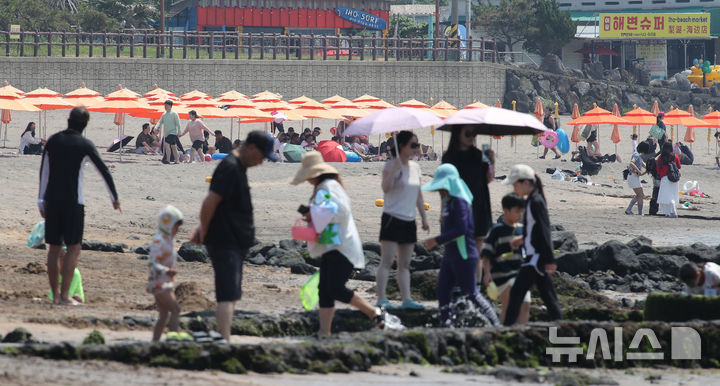 [제주=뉴시스] 우장호 기자 = 낮동안 더운 날씨를 보인 28일 오후 제주시 이호해수욕장을 찾은 피서객들이 바닷바람을 맞으며 더위를 식히고 있다. 2026.06.28. woo1223@newsis.com
