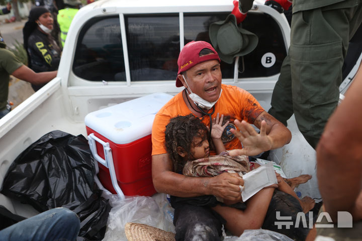 [라과이라=AP/뉴시스] 28일(현지 시간) 베네수엘라 라과이라 지진 피해 현장에서 한 구조대원이 구조한 소녀를 차에 태워 이동하고 있다. 2026.06.29.
