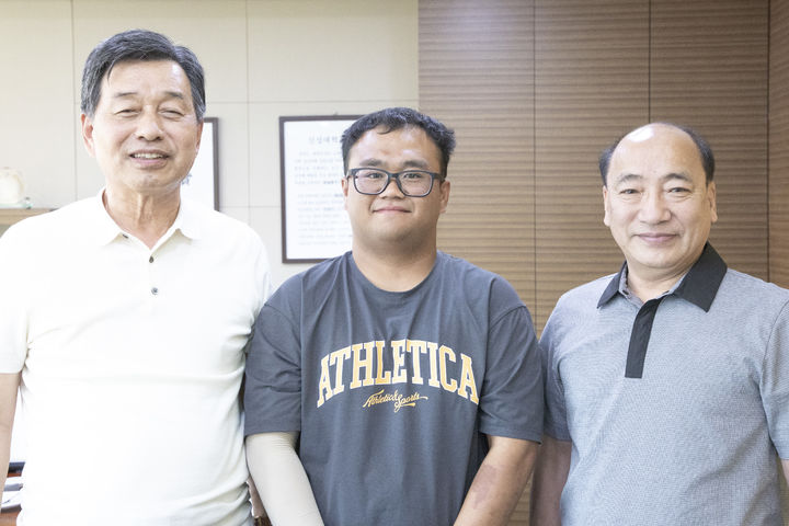 [당진=뉴시스] 지난 5월17일 오후 10시28분께 충남 당진시 신평면 농로에서 전신주를 들이받고 전복된 불이 난 차량 안에서 탑승자 4명을 구한 전민석(가운데) 학생이 서영범(왼쪽) 신성대학교 총장과 기념 사진을 찍고 있다. *재판매 및 DB 금지