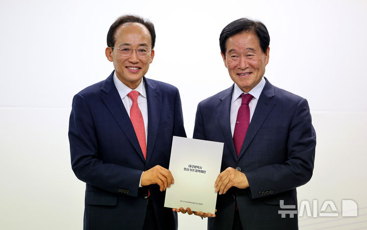 [대구=뉴시스] 이무열 기자 = 추경호(왼쪽) 대구시장 당선인이 29일 대구 동구 대구콘텐츠센터에서 열린 민선 9기 인수위 정책제안 전달식에서 곽대훈 인수위원장에게 정책제안서를 전달받은 뒤 기념촬영을 하고 있다. 2026.06.29. lmy@newsis.com