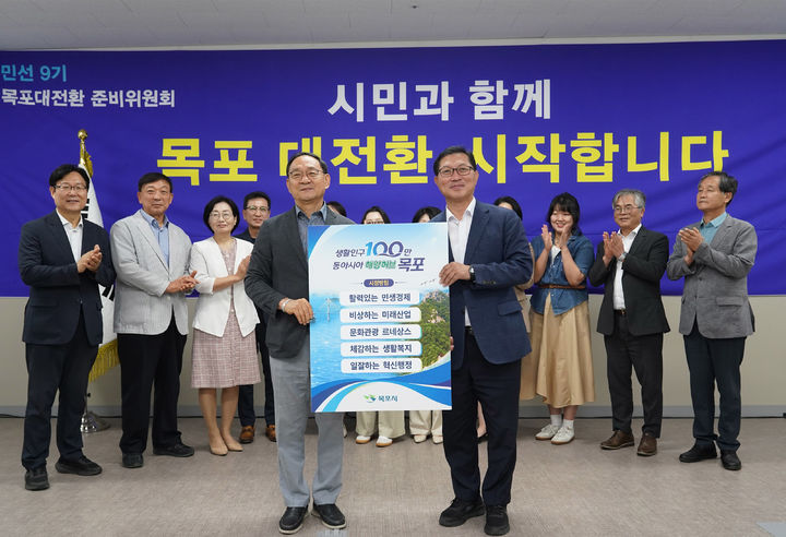 [목포=뉴시스]30일 열린 ‘목포대전환 준비위원회' 최종보고회에서 고석규 위원장이 강성휘 목포시장 당선인에게 민선 9기 시정 운영 방향과 100대 공약이 담긴 최종보고서를 전달하고 있다. (사진=목포대전환 준비위원회 제공) 2026.06.30. photo@newsis.com *재판매 및 DB 금지