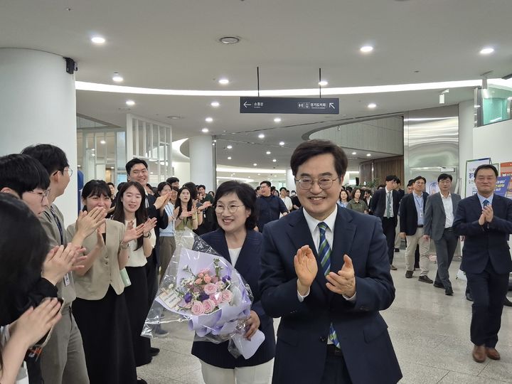 [수원=뉴시스] 이병희 기자 = 김동연 경기도지사와 배우자 정우영 여사가 30일 도청 1층에서 직원들의 배웅을 받으며 마지막 퇴근을 하고 있다. 2026.06.30. iambh@newsis.com *재판매 및 DB 금지