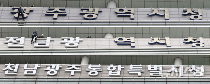 [광주=뉴시스] 이현행 기자 = 전남광주통합특별시 출범을 하루 앞둔 30일 오전 작업자들이 광주 서구 치평동 광주시청에 마련된 '광주광역시청' 간판을 철거하고 있다. 사진은 광주광역시청 간판이 전남광주통합특별시청 간판으로 교체되는 모습. 2026.06.30. lhh@newsis.com