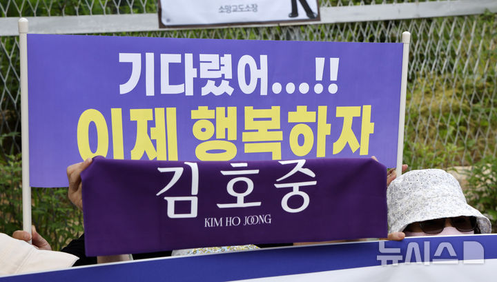 [여주=뉴시스] 김혜진 기자 = '음주 뺑소니' 등의 혐의로 실형을 산 가수 김호중이 출소하는 30일 오전 경기 여주시 소망교도소 앞에서 팬들이 플래카드를 들고 응원하고 있다. 2026.06.30. photo@newsis.com