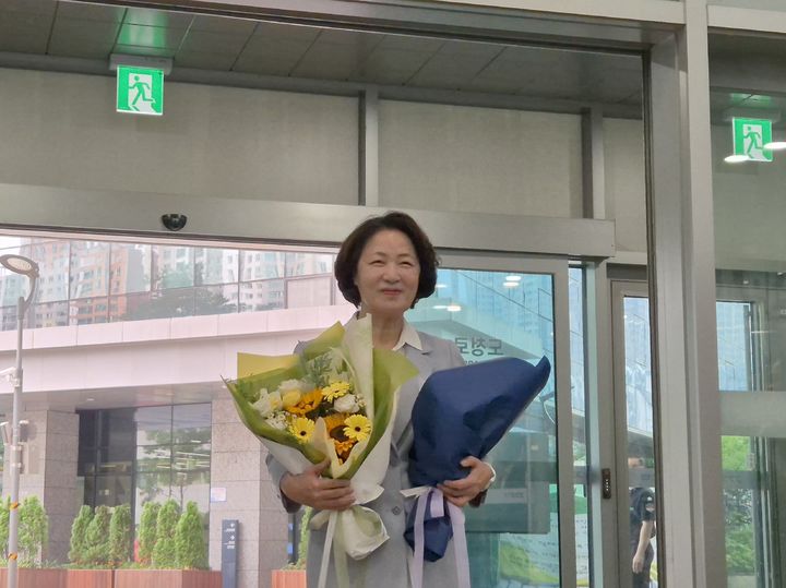 [수원=뉴시스] 이병희 기자 = 추미애 경기도지사가 취임 첫날인 1일 오전 9시 경기도청에 첫출근하며 직원들이 전달한 꽃을 받고 서 있다. 2026.07.01. iambh@newsis.com *재판매 및 DB 금지