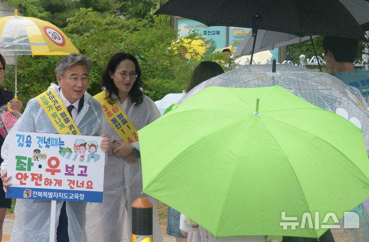 [전주=뉴시스] 김얼 기자 = 천호성(왼쪽) 전북특별자치도교육감이 30일 전북 전주시 전주효천초등학교를 방문해 취임 첫 일정으로 교통봉사를 하며 어린이들의 등굣길 안전에 힘쓰고 있다. 2026.07.01. pmkeul@newsis.com