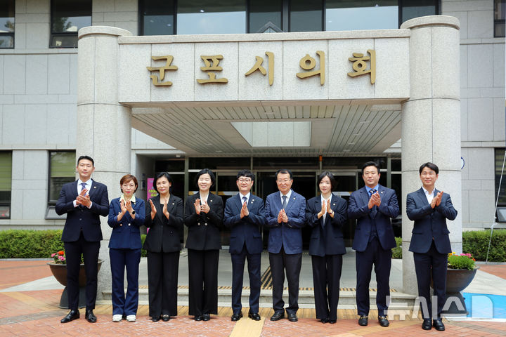 [군포=뉴시스] 제10대 군포시의회에 진출한 의원들이 의회 앞에서 박수를 치며 기념 촬영에 임하고 있다. (사진=군포시 의회 제공) 2026.07.01. photo@newsis.com