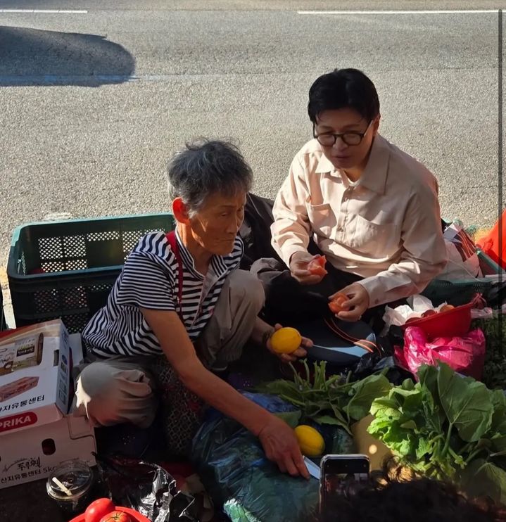 [서울=뉴시스] 무소속 한동훈 의원이 지난 주말 부산 구포시장을 방문해 '찰밥 할머니가 건넨 토마토를 먹고 있다. (사진출처: 한동훈 페이스북) 2026.07.01