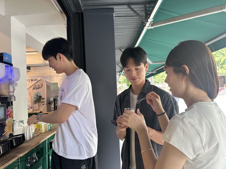 [서울=뉴시스] 막걸리 슬러시를 맛보고 있는 김민준 씨(사진 가운데)와 김정인 씨(사진 오른쪽)(사진=서울장수 제공) *재판매 및 DB 금지
