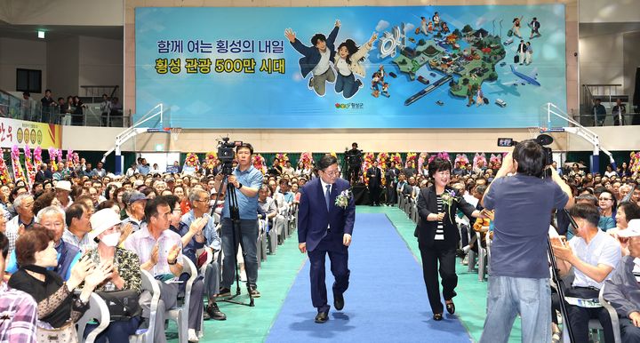 [횡성=뉴시스] 장신상 횡성군수 부부가 횡성실내체육관에서 열린 제47대 횡성군수 취임식에서 참석자들에게 인사하며 입장하고 있다. (사진=횡성군 제공) 2026.07.01. photo@newsis.com *재판매 및 DB 금지