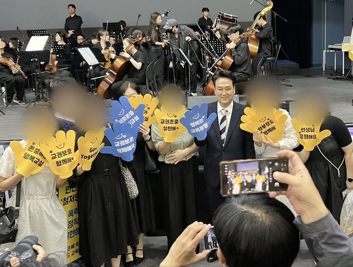 [수원=뉴시스] 김드보라 인턴기자 = 안민석 경기도교육감이 '행복한 교육동행' 문구가 적힌 장갑을 착용하고 시민들과 사진을 찍고 있다. *재판매 및 DB 금지