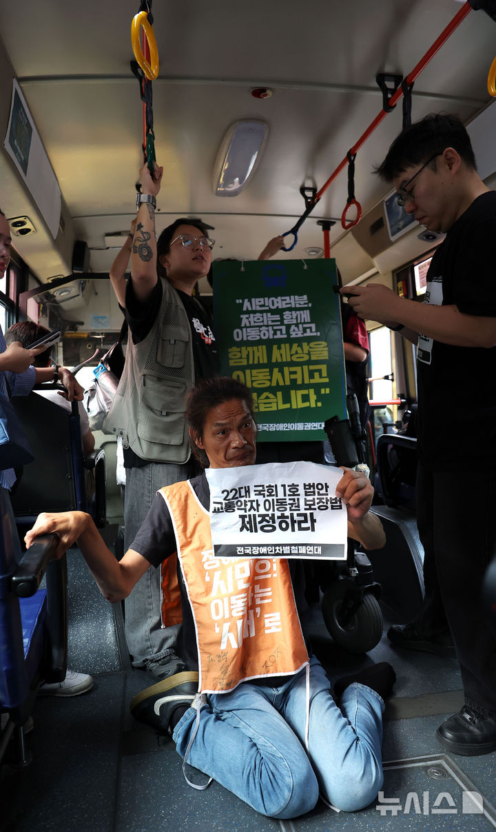 [서울=뉴시스] 김선웅 기자 = 전국장애인차별철폐연대 회원들이 1일 서울 종로구 혜화동의 버스정류장에서 버스에 탑승해 교통약자이동권보장법 전면 개정을 촉구하고 있다. 2026.07.01. mangusta@newsis.com