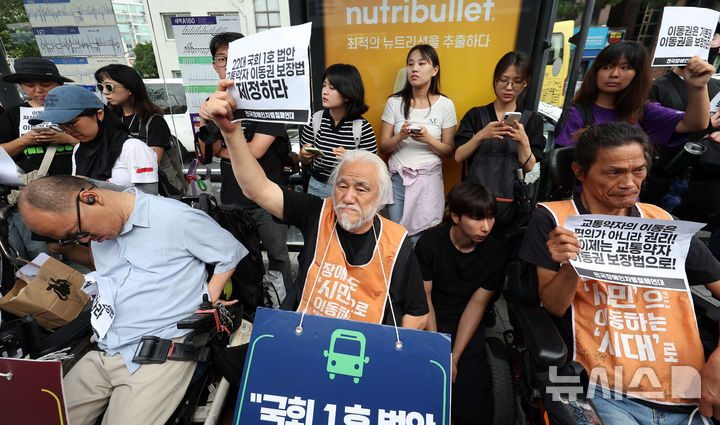 [서울=뉴시스] 김선웅 기자 = 박경석 대표 등 전국장애인차별철폐연대 회원들이 1일 서울 종로구 혜화동의 버스정류장에서 교통약자이동권보장법 전면 개정을 촉구하고 있다. 2026.07.01. mangusta@newsis.com