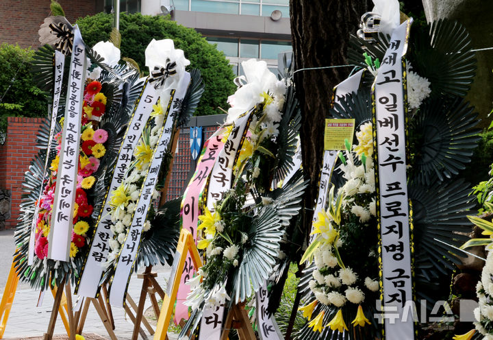 [서울=뉴시스] 권창회 기자 = 1일 오후 서울 강동구 배재고등학교 정문 앞에 근조화환이 늘어 서 있다.  지난달 29일 배재고는 청룡기 전국고교야구선수권대회 광주제일고와의 경기에서 "가야지, 가야지, 스타벅스 가야지", "탱크 데이"등 스타벅스의 '5·18 탱크데이' 논란을 연상시키는 구호를 외쳤다. 2026.07.01. kch0523@newsis.com