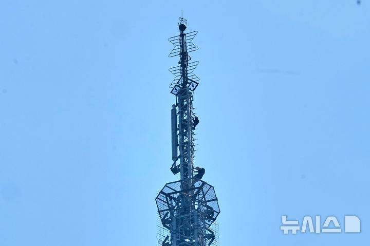 [뉴욕=AP/뉴시스] 러시아 출신 고공 스턴트 커플인 안젤라 니콜라우와 이반 비어쿠스 1일(현지 시간) 미국 뉴욕 엠파이어 스테이트빌딩 첨탑에서 내려오고 있다. 2026.07.02.