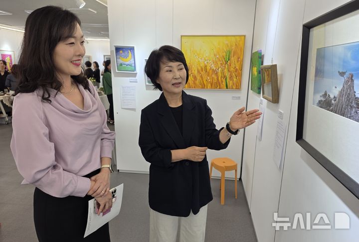[구미=뉴시스] 박홍식 기자 = 정미숙(오른쪽) 경북문화활짝피움 원장이 2일 구미시 금리단 상생팩토리 강당에서 열린 '도슨트 애장 전시회' 개막식에서 관람객에게 작품 설명을 하고 있다. 2026.07.02. phs6431@newsis.com