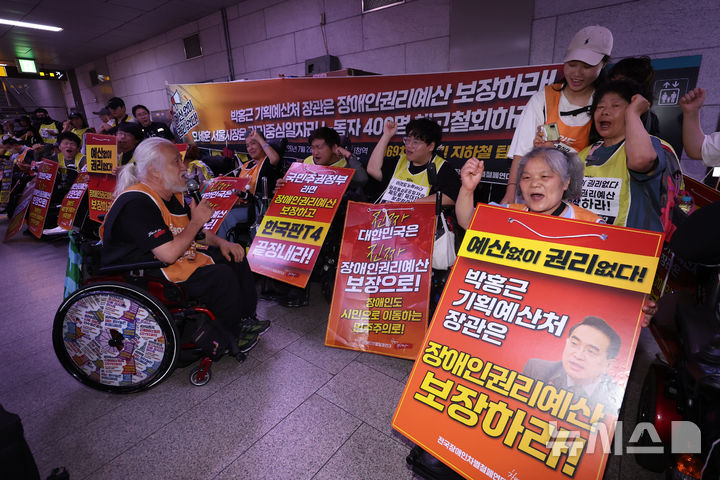 [서울=뉴시스] 권창회 기자 = 박경석 전국장애인차별철폐연대(전장연) 상임대표를 비롯한 회원들이 지난달 2일 오전 서울 중구 1호선 시청역에서 '69차 출근길 지하철 탑니다' 시위에서 구호를 외치고 있다. 2026.07.02. kch0523@newsis.com