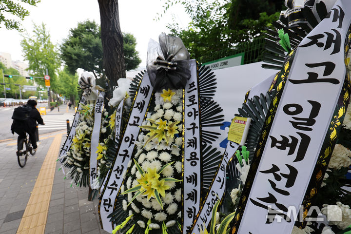[서울=뉴시스] 조성우 기자 = 지난달 29일 고교야구 대회 도중 광주일고를 향해 '스타벅스 가야지' 응원 구호를 외쳐 논란을 빚은 배재고 야구부를 비판하는 근조 화환이 2일 서울 강동구 배재고등학교 앞에 놓여 있다.대한야구소프트볼협회는 전날 스포츠공정위원회를 열고 배재고 야구부에 전국대회 출전 정지 6개월 중징계를 내렸다. 2026.07.02. xconfind@newsis.com